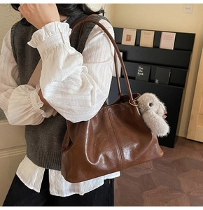 Détail du grand sac cabas en cuir marron foncé avec un pendentif lapin en peluche gris