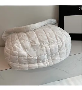 Detailed view of the soft quilted texture and pearl white fabric of this puffer cloud bag