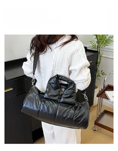 Detail shot of black quilted puffer bag featuring high-gloss nylon and shoulder strap