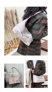 Détail d'un sac hobo beige en forme de lune avec bandoulière réglable et boucles en métal