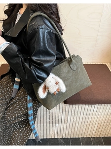 Sac fourre-tout vert mousse foncé avec charm lapin en peluche porté à l'épaule, style urbain