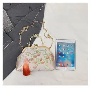 Detail of pink satin embroidery bag with persimmon pattern and decorative tassel
