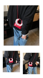 Detail view of red polka dot mini crossbody bag with white lace ruffle edges and thin strap