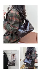 Détail du sac sous le bras marron foncé brillant avec boucles métalliques décoratives