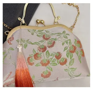 Close-up of Chinese style embroidery bag with persimmon pattern and silk tassel detail
