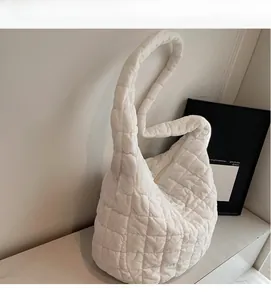 Detail of white quilted puffer shoulder bag showing soft padded fabric and cloud texture