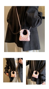 Detail of pink polka dot crossbody bag with white lace ruffle handle decoration