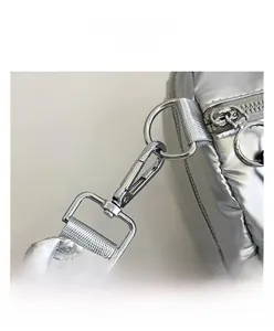 Detail of silver metallic quilted bag with shiny metal hook and high-quality stitching