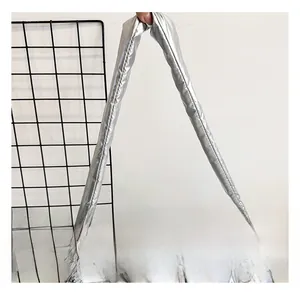 Detail of a padded silver quilted shoulder bag featuring a wide comfortable long strap