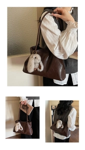 Détail d'un grand sac cabas en similicuir marron avec pendentif lapin et bandoulières