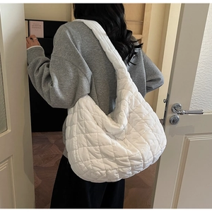 Rear view of a large white quilted puffy crossbody bag showing daily commute styling