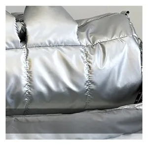 Close-up of metallic silver quilted fabric with padded texture on a spacious shoulder bag