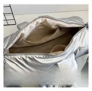 Interior layout of silver puffy bag featuring a zipper pocket and two open slip pockets