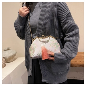 Detail of vintage shell bag with floral embroidery and long pink tassel fringe