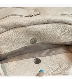 Detail of lychee pattern leather tote with magnetic buckle and silver metal zipper