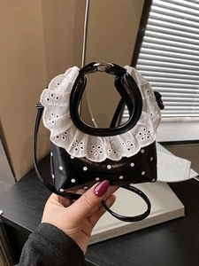 Mini black polka dot crossbody bag with white lace trim and round metal handle