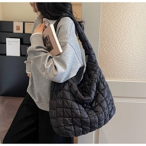 Close-up of the quilted texture and puff design on the black nylon cloud shoulder bag