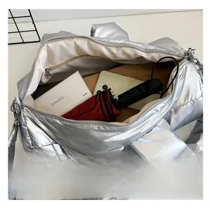 Interior view showing large capacity of silver quilted down bag with inner zip pocket