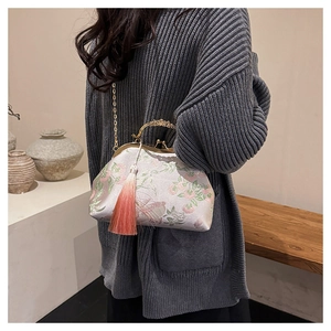 Detailed embroidery and golden vintage clasp on a lilac satin chain shoulder bag