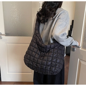 Close-up of the black quilted puffer shoulder bag showing large capacity and soft texture
