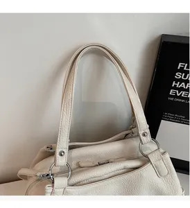 Close-up of white lychee pattern leather tote with silver metal ring and rivets