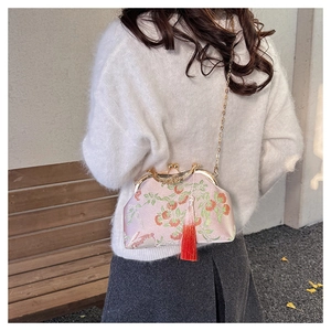 Pink embroidered silk qipao bag with red berries and tassel on a chain strap
