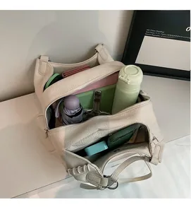 Spacious interior of beige pebbled leather shoulder bag showing ample storage space