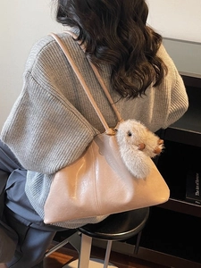 Grand sac cabas beige en cuir souple avec pendentif lapin et design minimaliste élégant