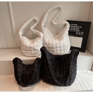 Close-up of puffer quilted bag in black and white colors with various sizes