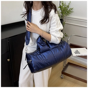 Close-up of the dark blue quilted puffer bag featuring a glossy nylon finish and soft texture