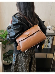Detail of vintage brown leather bag with golden twist lock and textured finish
