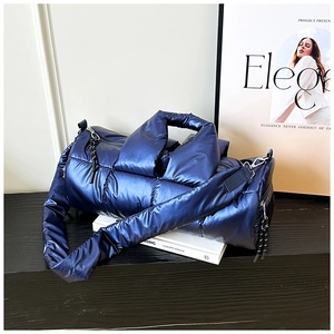 Close-up of a quilted deep blue metallic puffer bucket bag with soft padded handles