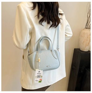Detail der hellblauen Handtasche aus Leder mit Litschimuster und verstellbarem Schultergurt
