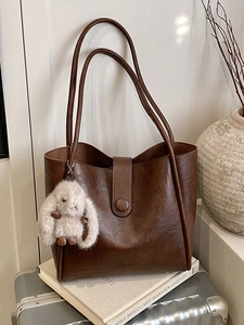 Retro brown leather tote bag with ROCOMO branding and cute plush bunny charm accessory