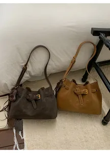 Détails de sacs bandoulière vintage en cuir avec boucles et breloques cœur sur tapis