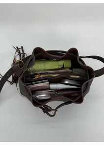 Vue intérieure du sac seau marron foncé montrant sa capacité et ses détails en métal doré