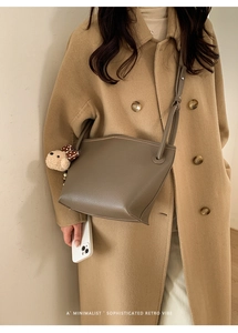 Sac seau en cuir grainé avec charme d'ours mignon sur un manteau en laine
