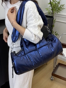 Quilted navy blue puffer cylinder bag with metallic finish and wide shoulder strap