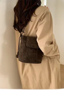 Vue détaillée du sac seau en daim marron foncé avec cordon de serrage et texture mate
