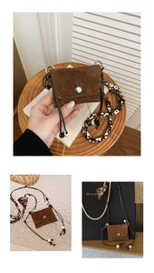 Macro detail of dark brown suede mini bag with decorative silk scarf on the strap