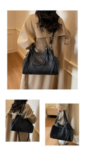 Detail of black lychee grain leather underarm bag with decorative woven stitching