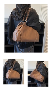 Close-up of brown textured leather tote with embossed AO logo and woven stitching details