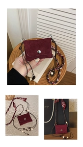 Detail of burgundy suede mini bag featuring unique wooden beads and silk scarf strap