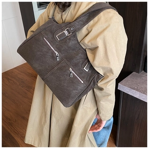Detail of vintage brown tote bag with dual zipper pockets and silver metal hardware