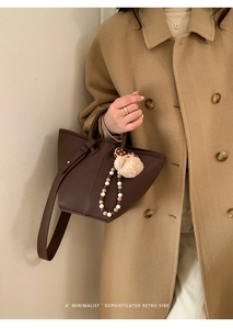 Vue détaillée du sac seau en cuir marron foncé avec pendentif champignon et perles