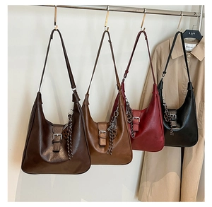 Detail view of crescent underarm bags in brown, red and black textured PU leather
