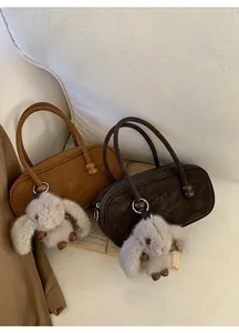 Detail of suede leather bowling bags with wooden ball accents and cute bunny pendants