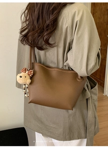 Vue arrière du mannequin portant le sac seau marron foncé avec breloque chiot et perles