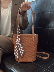 Brown woven bucket bag with polka dot scarf detail and adjustable shoulder strap