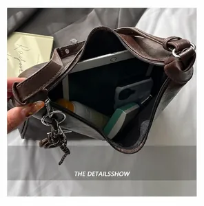 Macro view showing internal capacity of the brown shoulder bag for tablets and phones